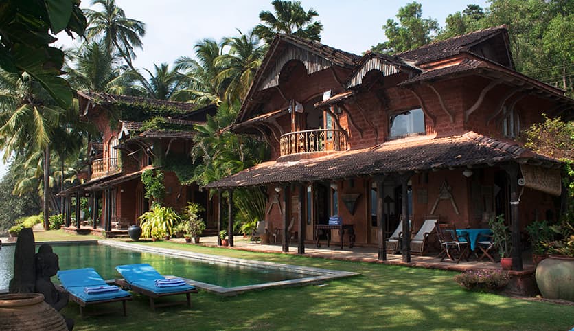 Tiled-roof villas, palm gardens and pool at Ahilya by the Sea in Goa