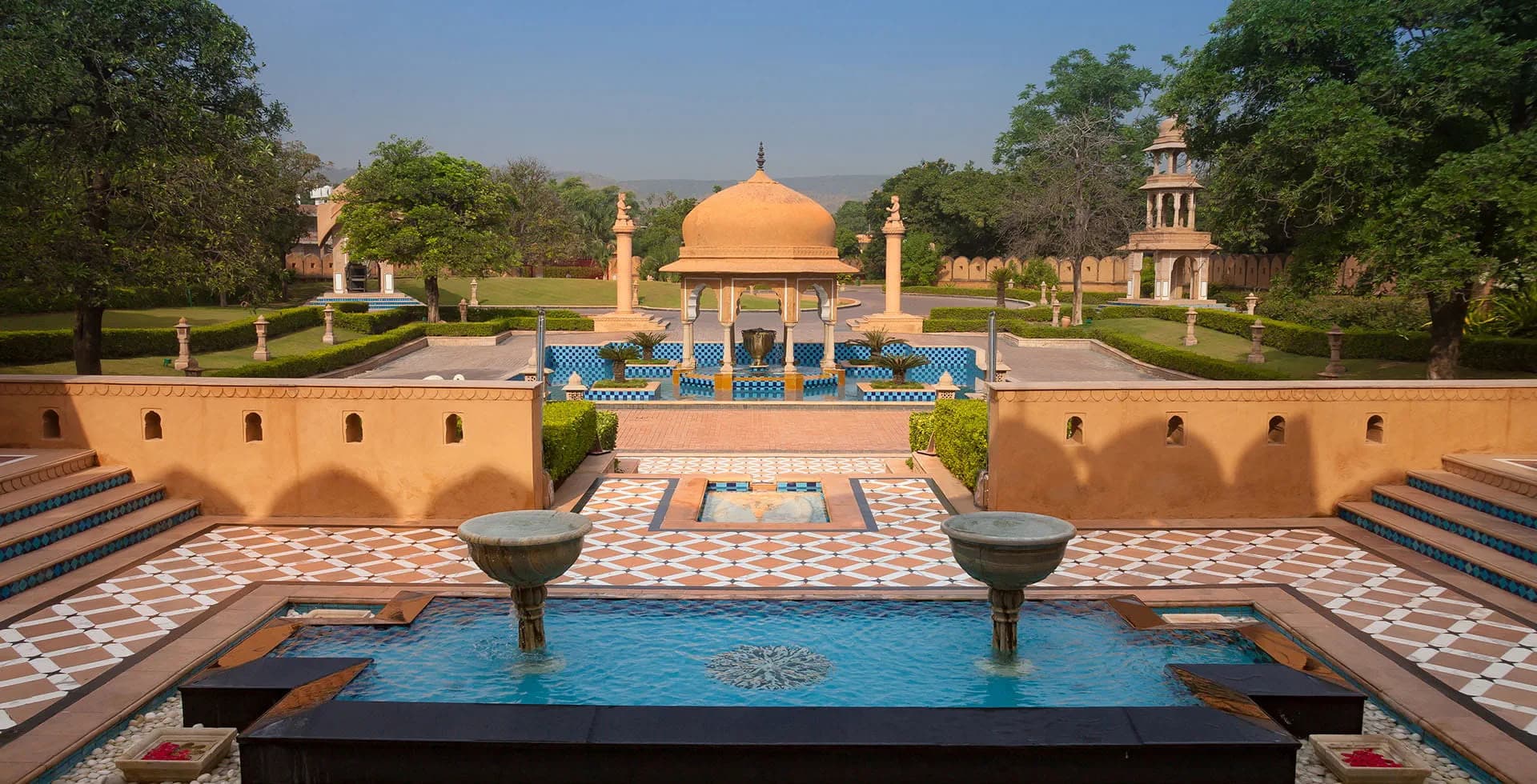 Pool, fountains and domed pavilions in the gardens of The Oberoi Rajvilas, Jaipur