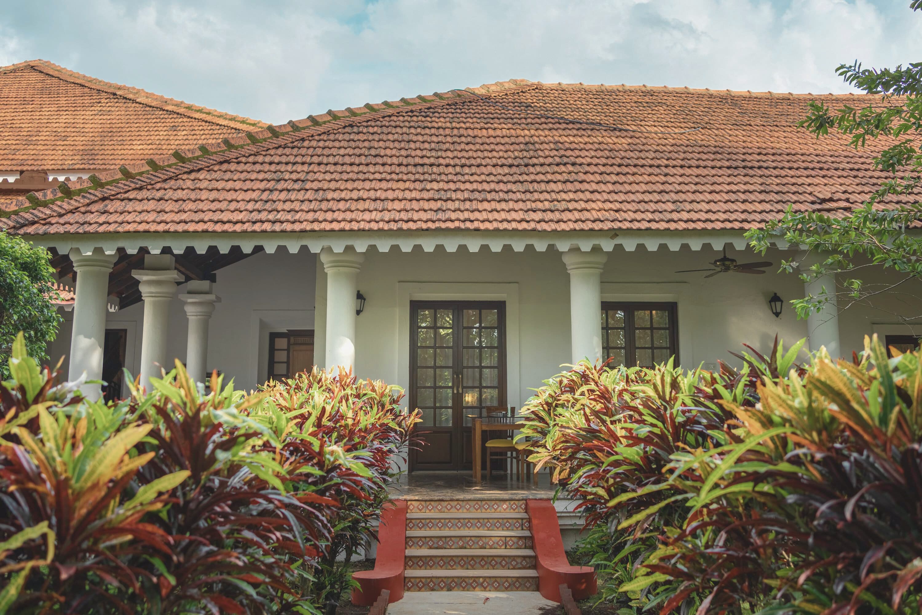 White-columned veranda and tiled roof at The Postcard Cuelim in South Goa